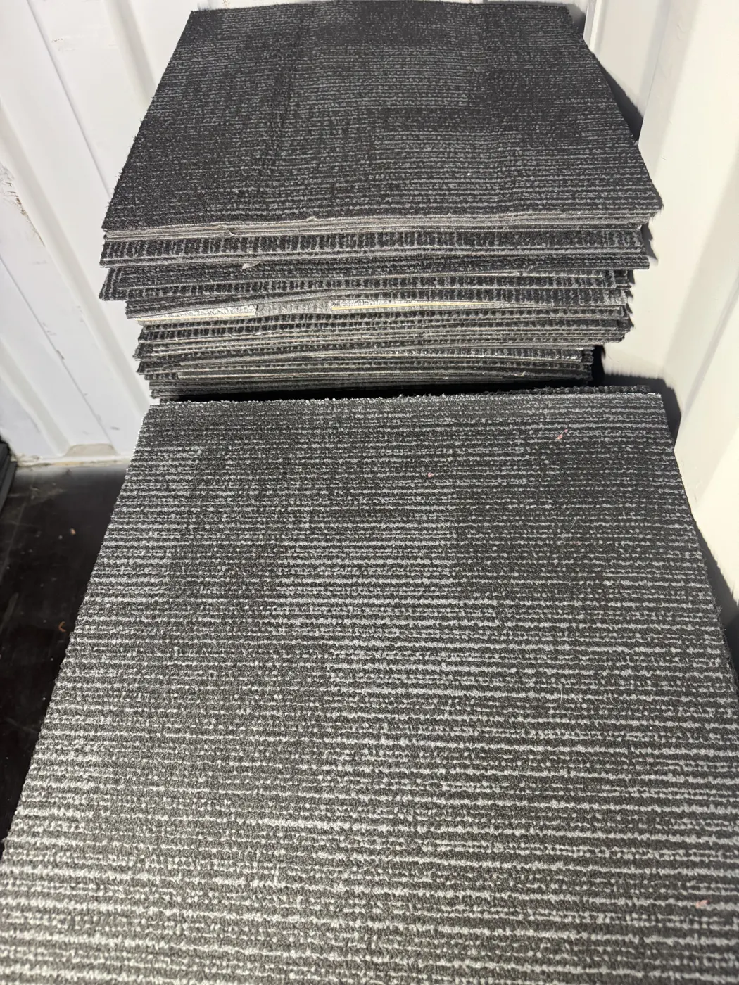 Boxed carpet tiles loaded in a van for collection